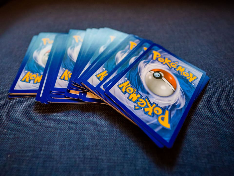 Ein Fächer aus Pokémon-Sammelkarten auf blauem Stoff